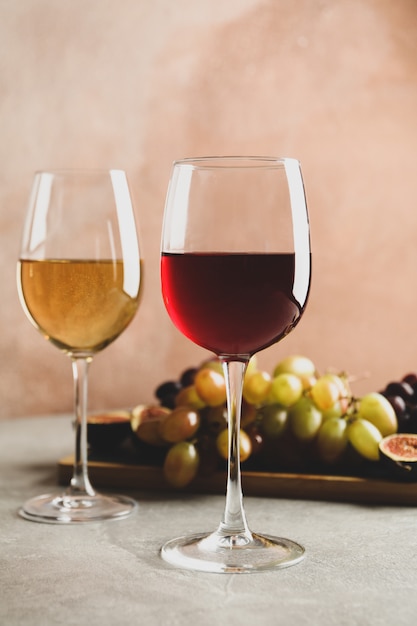 Composition with glasses of wine and grape on gray table