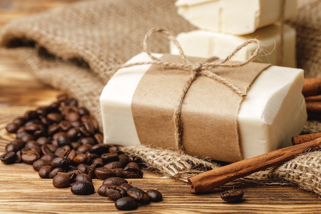 Composition with grains of coffee, soap on the wooden table, close up