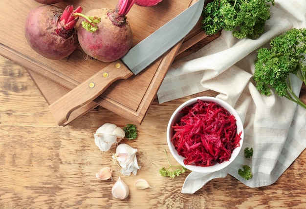 Composition with grated beetroot on wooden table