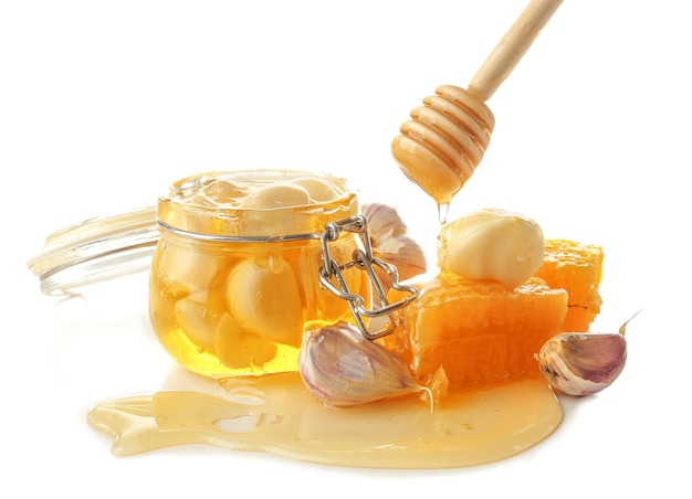 Composition with honey and garlic as natural cold remedies on white background