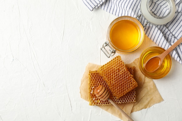 Composition with honeycombs and honey on white background