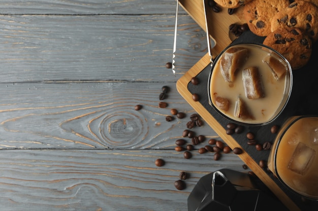 Photo composition with ice coffee and cookies on wooden background