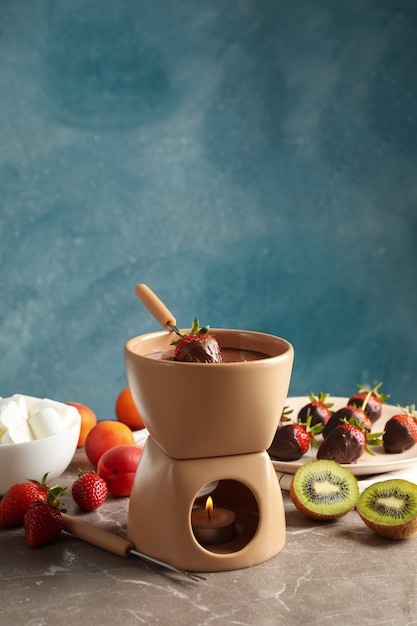 Composition with ingredients for chocolate fondue on gray table. Cooking fondue