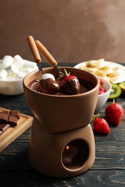 Composition with ingredients for chocolate fondue on wooden background. Cooking fondue