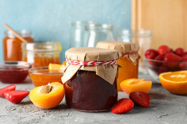 Photo composition with jam and ingredients on gray table, close up