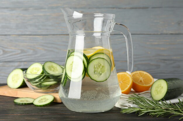 Composition with jug of infused water on wooden surface