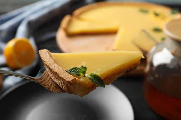 Composition with lemon tart slice on spatula, close up