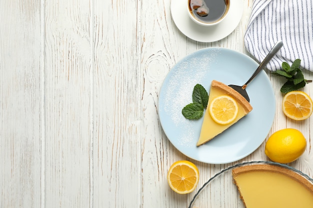 白い木製の背景にレモンのタルトと組成。甘い朝食