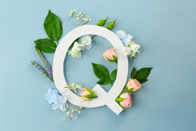 Composition with letter Q and beautiful flowers on color background