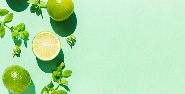 Composition with limes and mint in the morning light. Trendy sunlight shadows. Top view with copy space for text.