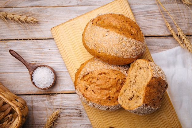 Composizione con pagnotte di pane di frumento sul tavolo di legno