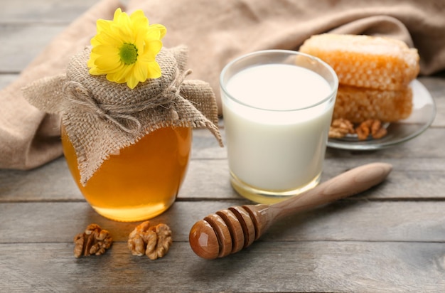 Composition with milk and honey on wooden background