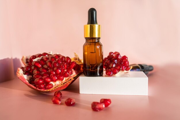 Composition with natural cosmetic oil and pomegranate on light background. High quality photo