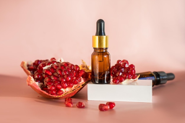 Composition with natural cosmetic oil and pomegranate on light background High quality photo