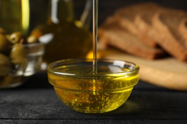 Photo composition with olive oil, bread and olives on wooden, close up