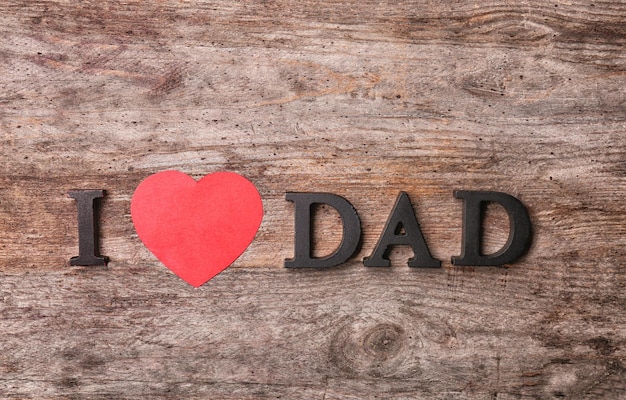 Photo composition with phrase i love dad for father's day on wooden background