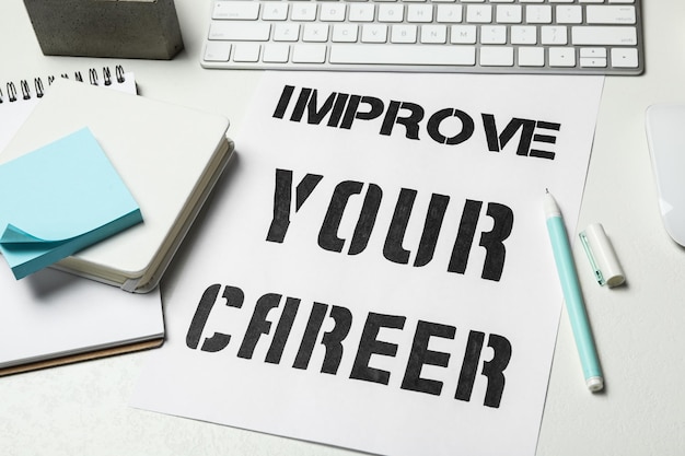 Photo composition with phrase improve your career on white table