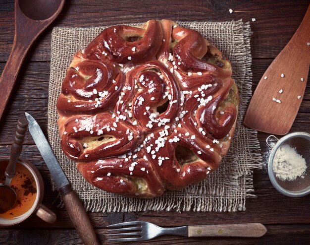 Composition with pie and kitchen utensils on wooden background, top view. Toned photo