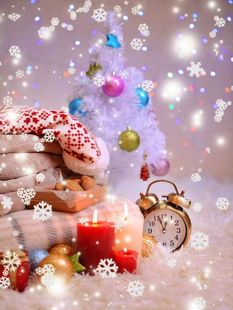 Composition with plaids, candles and Christmas decorations, on white carpet on bright background