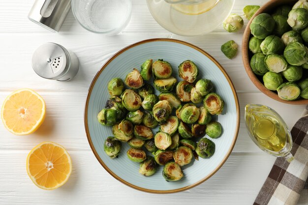 Composition with plate of brussels sprout on wooden background, top view