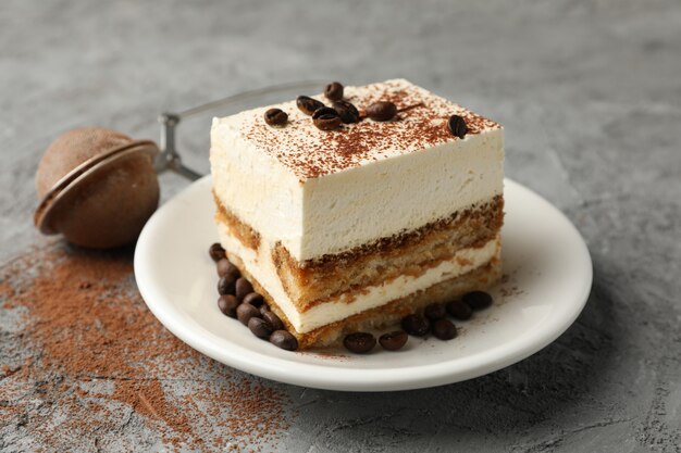 Composition with plate of tasty tiramisu on gray background