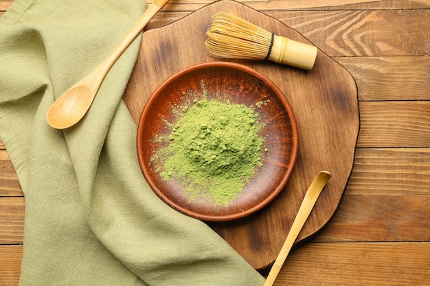 Composition with powdered matcha tea on wooden background