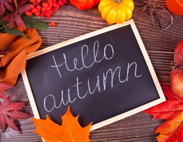 Foto composizione con zucca, foglie di autunno, cadle e pere rosse su legno, piatto laici