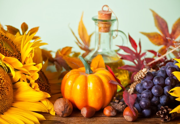 Composition with pumpkin, autumn leaves, sunflower and berries on the wooden table