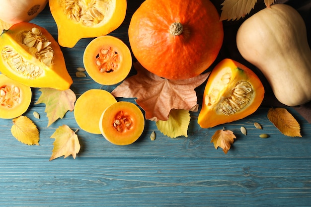 Composition with pumpkin, squash, seeds and leaves on wood