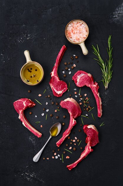 Composition with rack of lamb, seasoning and herbs on dark background