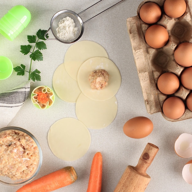 Composition with Raw Dumplings (Dim Sum) and Ingredients on White Marble Background. Copy Space for Text, Process of Cooking Making Shumay, Steamed Chinese Dimsum