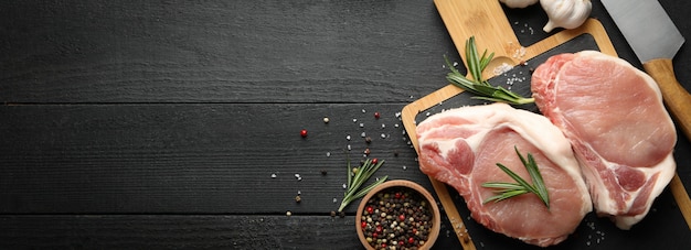 Composition with raw meat for steak and spices on wooden table