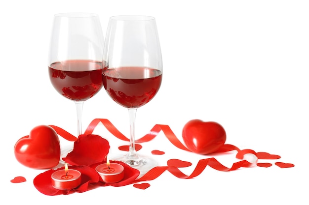 Composition with red wine in glasses, red roses, ribbon and decorative hearts on light background