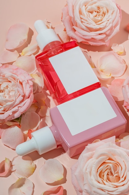 사진 분홍색 배경 화장품 패키지 모형에 장미 에센셜 오일과 꽃을 사용한 구성