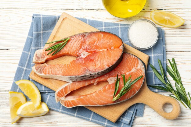 Composition with salmon meat and spices on wooden background, top view