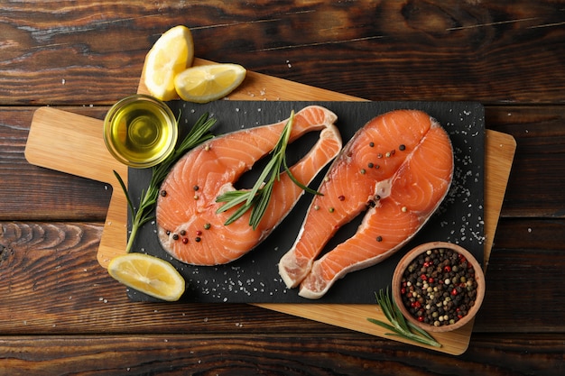 Composition with salmon meat and spices on wooden background, top view