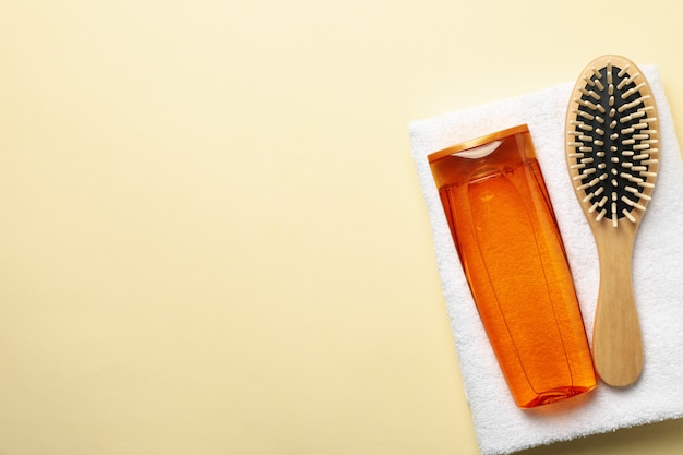 Photo composition with shampoo bottle on beige background, space for text