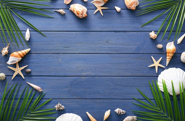 Composition with shells and leaves on wooden background Summer vacation concept