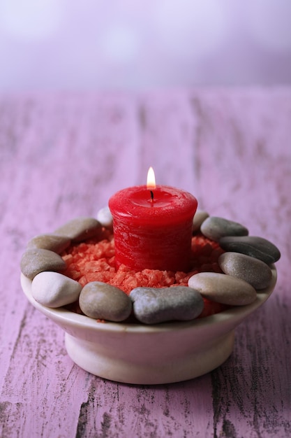 Composition with spa stones candle on color wooden table background
