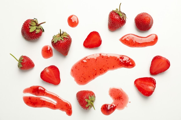 Composition with strawberry and jam on white background