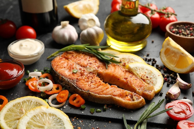 Composition with tasty grilled salmon on black table, close up