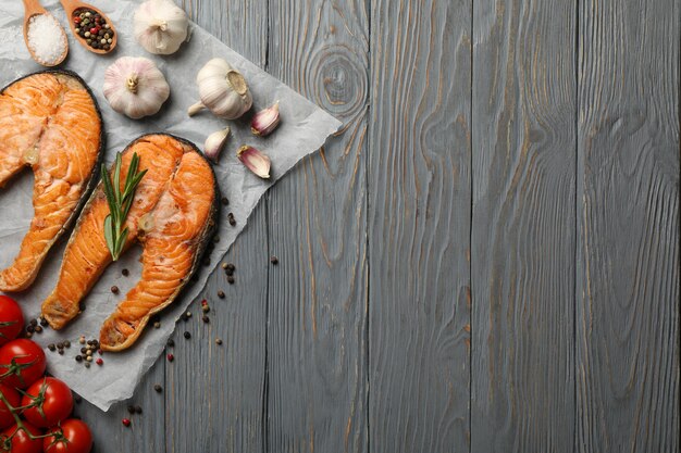 Composition with tasty grilled salmon on wooden background, top view