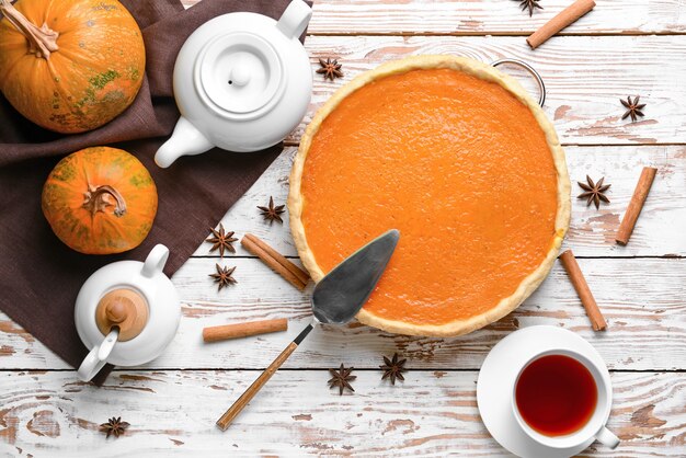 Composition with tasty pumpkin pie and tea on wooden table