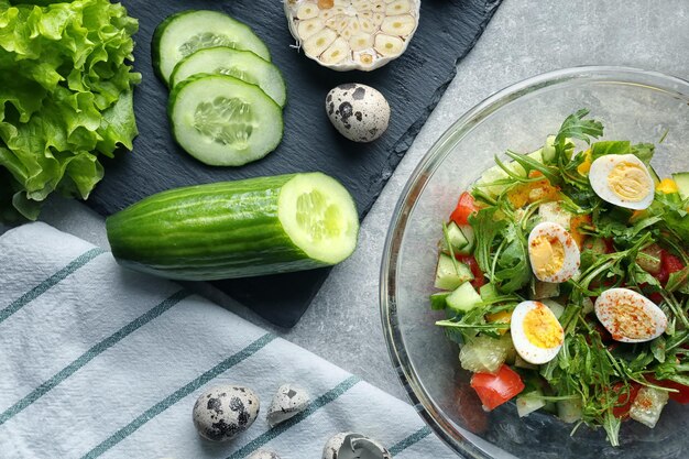 Composition with tasty vegetable salad and ingredients on table