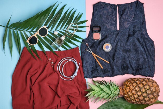 Photo composition with trendy clothes and tropical leaves on color background