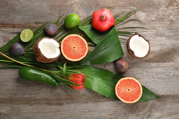 Composition with tropical leaves and exotic fruits on table