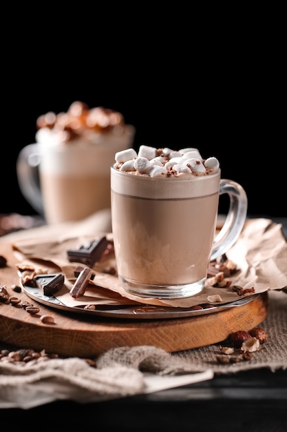 Foto composizione con due bicchieri di cappuccino conditi con marshmallow e servito