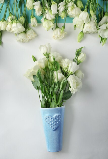 Composition with vase of beautiful flowers on color background