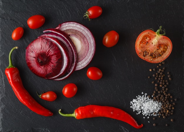 Composition with vegetables and spices on black kitchen table