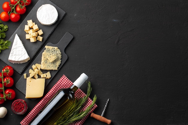 composition with wine bottle and cheese assortment on grey background